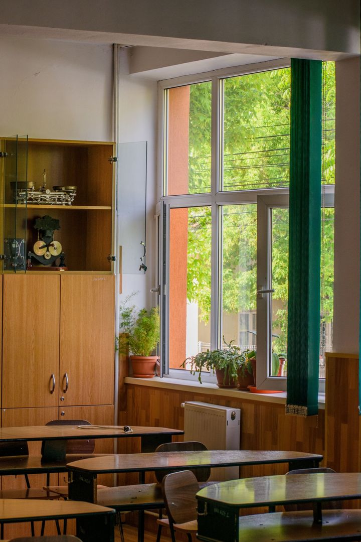 Salón de clases con pupitres y ventanales en una institución educativa