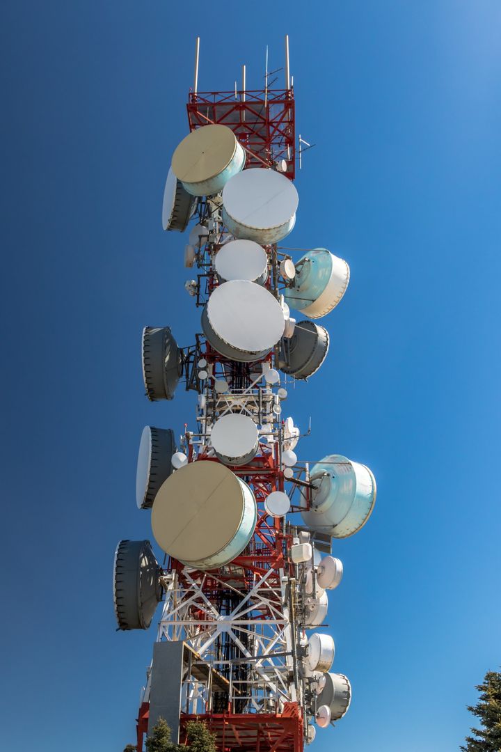 Torre de telecomunicaciones con antenas contra un cielo azul